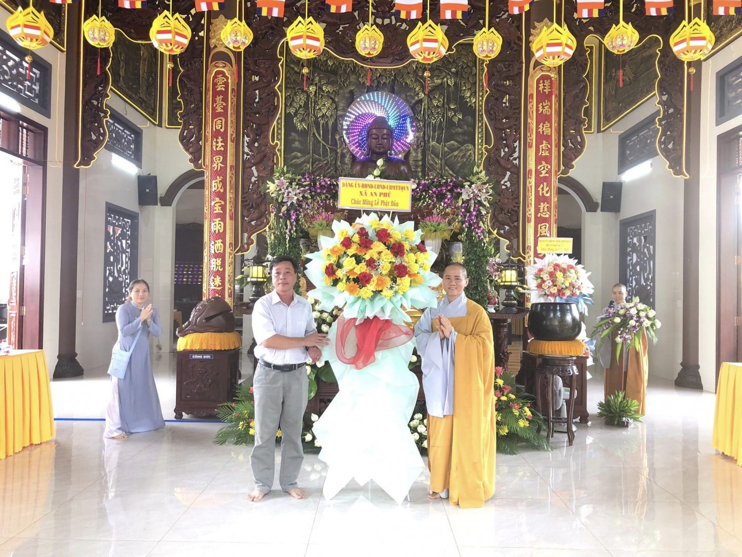 Đồng chí Mai Hoàng Phúc-PBT Đảng uỷ-Chủ tịch UBND xã tặng hoa chúc mừng